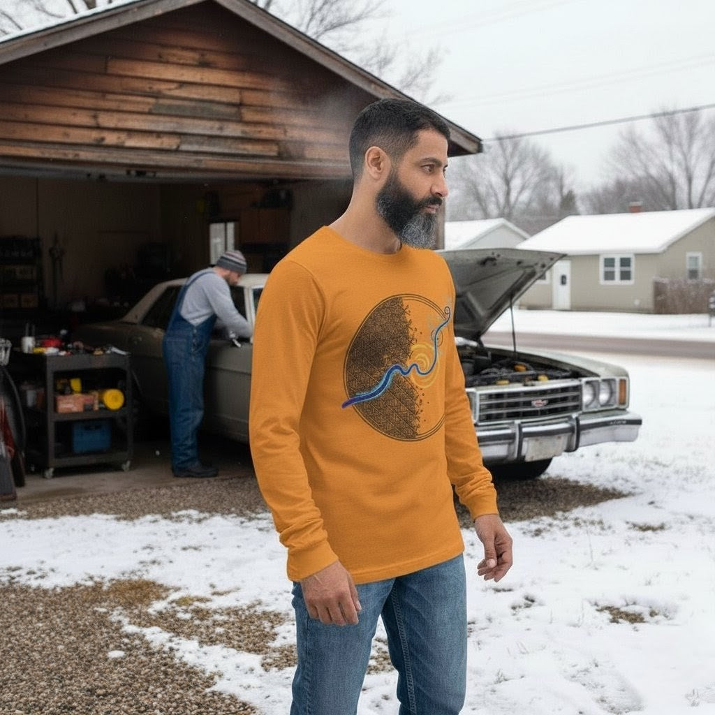 Man wearing a yellow long-sleeve shirt with a graphic design, standing in front of a car with an open hood in a snowy driveway.