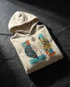 Bone Output Hoodie folded on dark stone, showing a divided dark and golden sphere with red lightning, a branch and blue flowing lines.