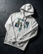 White Insolvent Hoodie folded on dark stone, showing geometric creditor and debtor figures, stacked gold and tangled black lines.
