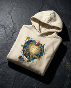 Bone Imperishable hoodie folded on dark stone, showing a blue and teal mosaic heart, golden cross of light and red bolt.