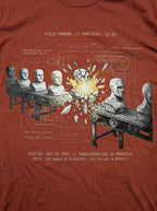 Close-up of a heather clay T-shirt's front print showing conveyor belts carrying gray busts around a bright yellow burst, with technical linework and OUT OF SPEC text.