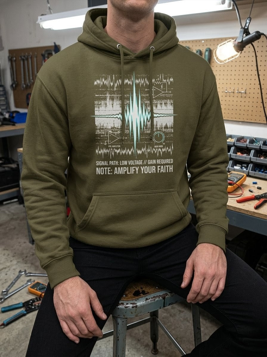 Person in a tool-filled workshop wearing a Selah Supply Co Military Green graphic hoodie with a chaotic noise floor and high-amplitude signal path design representing fervent prayer