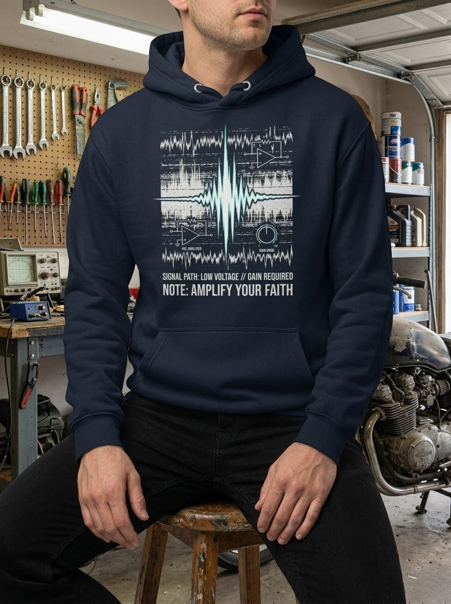 Model in a mechanical garage setting wearing a Selah Supply Co Navy Blazer hoodie with a technical pre-amp schematic and 'Amplify Your Faith' operational command text. 