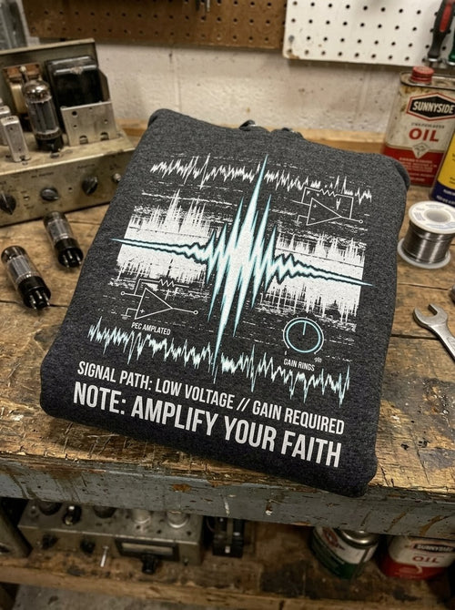Black t-shirt with technical design and text on a workshop table