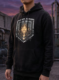 Model wearing the Selah Supply Co. Black Transmission: Mustard // FREQ 13.03 streetwear hoodie, displaying the industrial brutalist graphic design in a concrete setting.