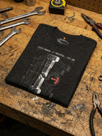 Dark Grey Heather Torque tee laid flat on a workbench among tools, showing the sheared bolt and red gauge.