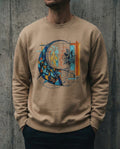 Selah Supply Co. The Separation Crewneck in Latte. Model wearing a Christian graphic sweatshirt that visualizes the Parable of the Net (Matthew 13:47) through abstract geometric fish and a striking red line of separation.