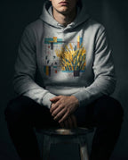 Model wearing the Carbon Grey Nine 37 Hoodie with gold wheat, small figures and geometric grid artwork.