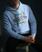 Model wearing the Carolina Blue One Percent hoodie, showing geometric sheep, blue and gold bars and a red scribble separating one sheep from the flock.