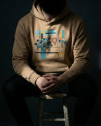 Model wearing the Latte One Percent hoodie, showing geometric sheep, blue and gold bars and a red scribble separating one sheep from the flock.