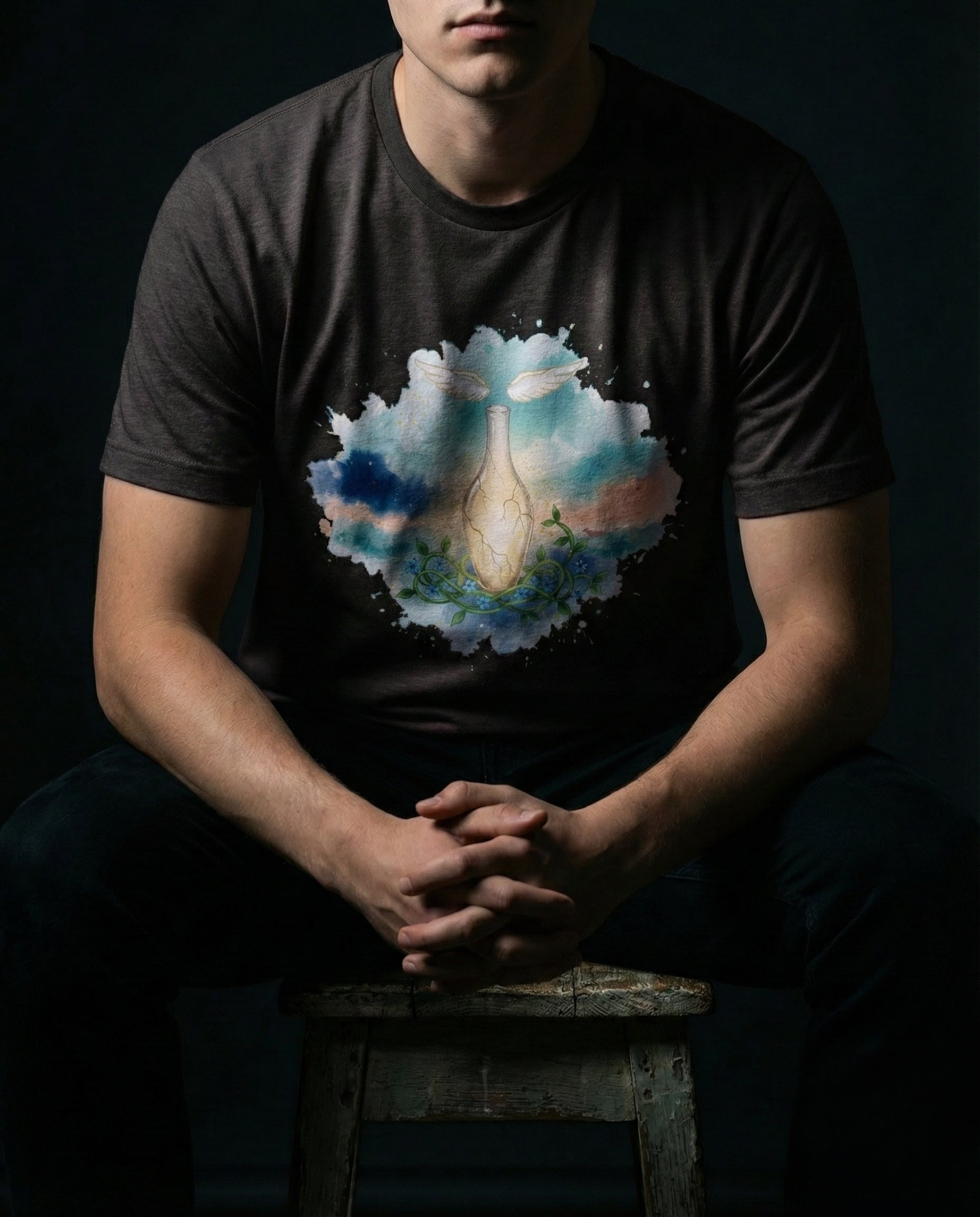 Person wearing a t-shirt with a colorful graphic design on a dark background