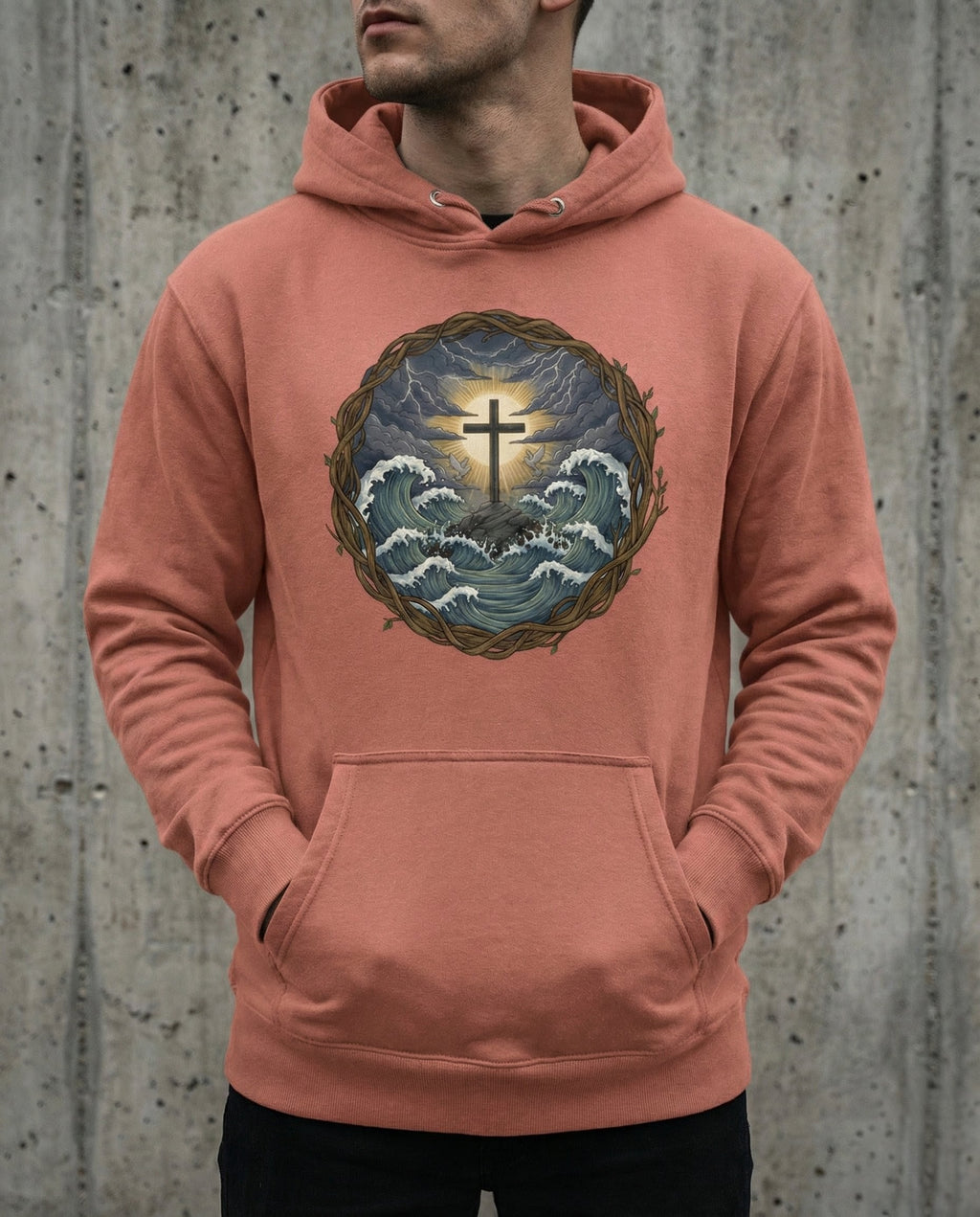 Model wearing the Dusty Rose Trouble Hoodie with cross above storm waves within a thorn border.