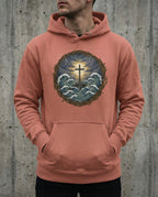 Model wearing the Dusty Rose Trouble Hoodie with cross above storm waves within a thorn border.