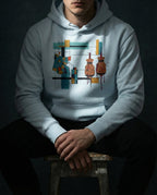 Model seated wearing the Sky Blue Expansion Hoodie with a geometric cloth patch, two wineskins and dark drips within a colored grid.