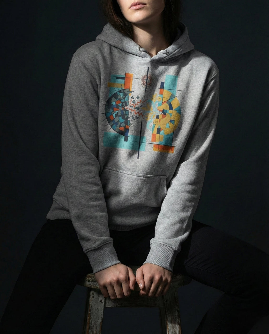 Model wearing the Carbon Grey Output Hoodie with a divided dark and golden sphere with red lightning, a branch and blue flowing lines.