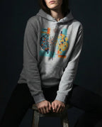 Model wearing the Carbon Grey Output Hoodie with a divided dark and golden sphere with red lightning, a branch and blue flowing lines.