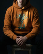 Model wearing the Adobe Thirty Sixty Hundred Hoodie with a tall teal, navy and gold spray of seeds and leaves above small seedlings.