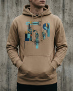 Model wearing the Latte Insolvent Hoodie with geometric creditor and debtor figures, stacked gold and tangled black lines.