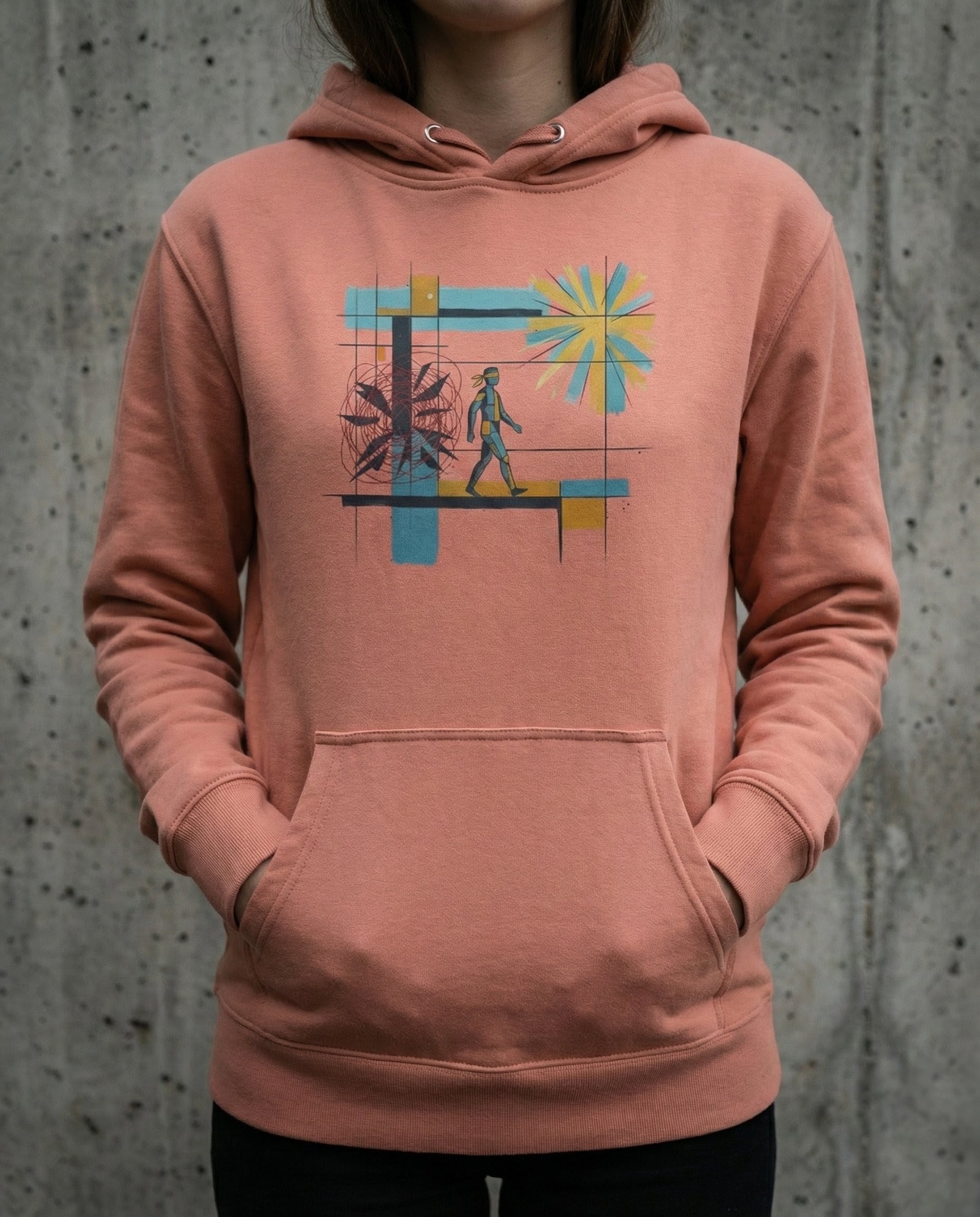 Person wearing a pink hoodie with a colorful graphic design on a concrete background