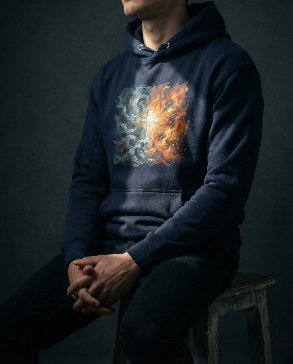 Model wearing the Navy Blazer Unconsumed Hoodie with blue waves and orange flames surrounding a glowing cross on the front.