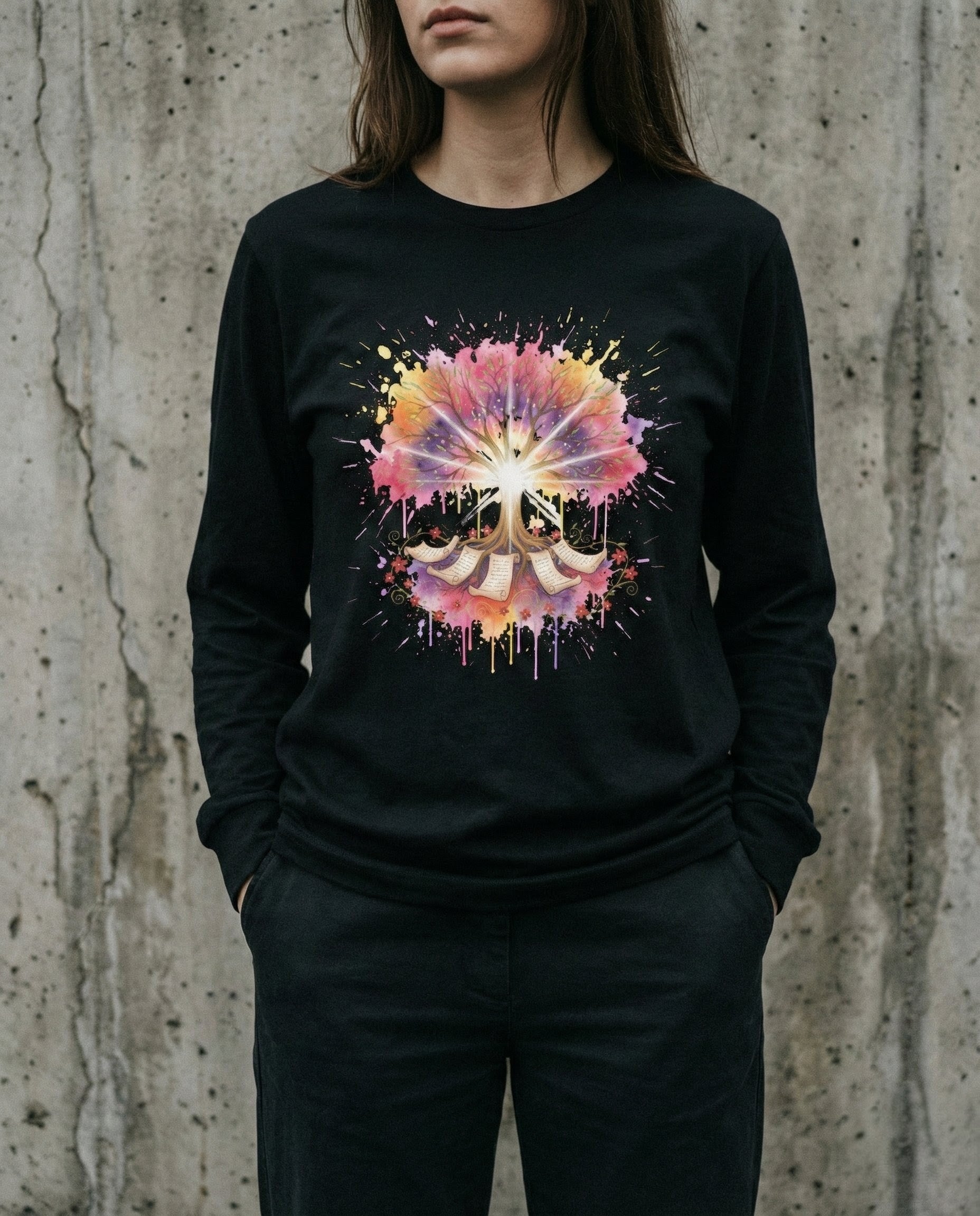 Person wearing a black long-sleeve shirt with a colorful abstract design against a concrete wall.