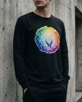 Person wearing a black sweatshirt with a colorful abstract design against a concrete wall.