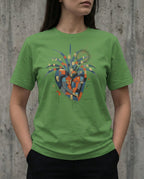 Model wearing the leaf green East West Tee with a geometric heart, blue wing-like forms, gold squares and red and black scribbles.
