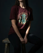 Model wearing the Oxblood Black Secret Tee with circular cross, winding helix, figures and heart artwork on the front.