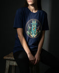Selah Supply Co. The Secret Tee in Navy. Model wearing a Christian graphic tee that visualizes the 'Divine Supply Line' of Philippians 4:13 through a central glowing cross, winding helix, and figures standing on rocky ground.