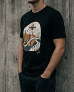 Model wearing the Vintage Black Lean Not Tee with hands, geometric heart, winding white path and cross artwork on the front.