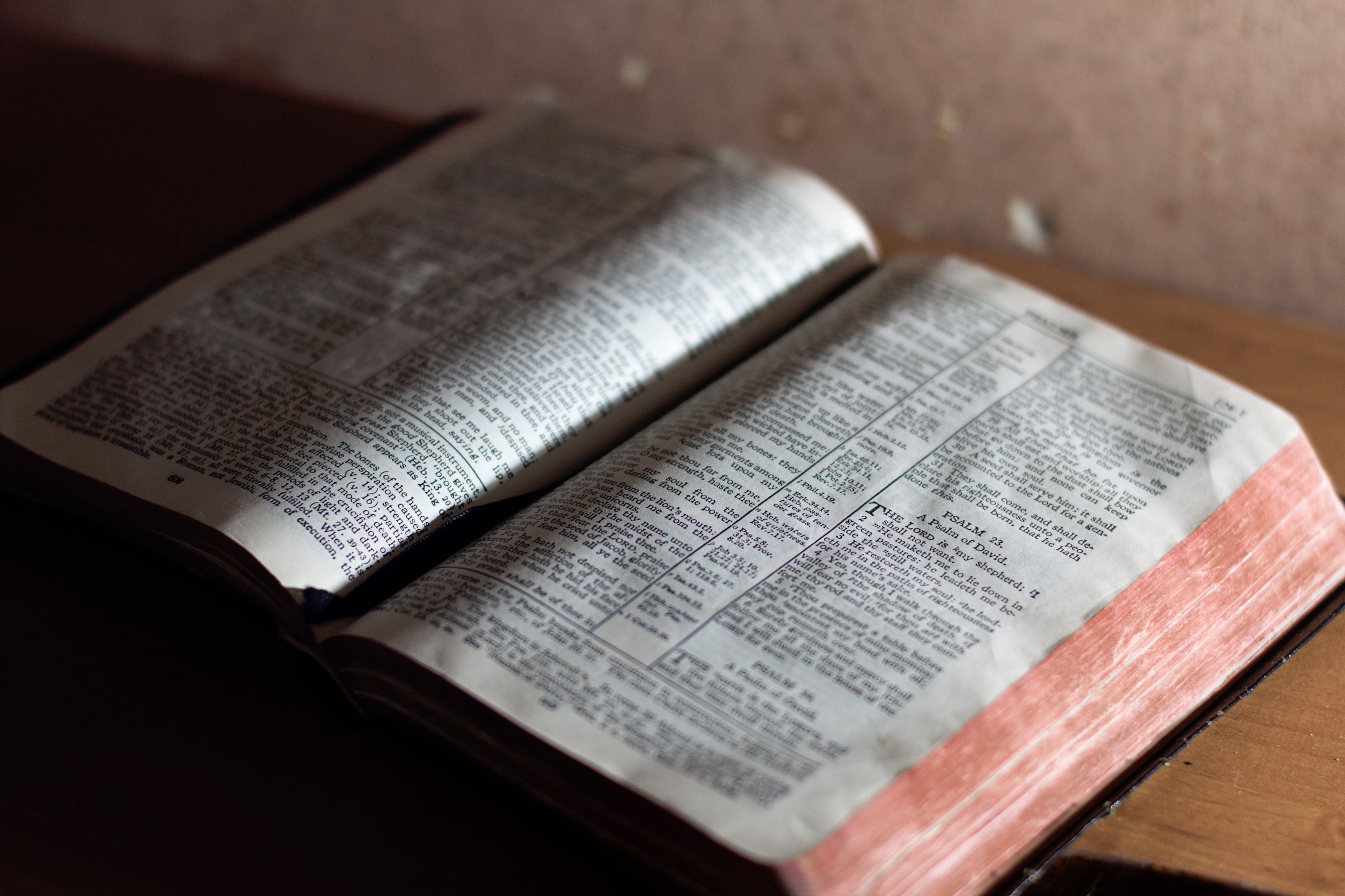 An open Bible serves as the background for the website's main slogan, 'Designed to Inspire'.