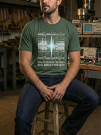 Model seated in an electronics workshop wearing a Heather Forest Gain tee with a pale blue waveform and white circuit diagrams.