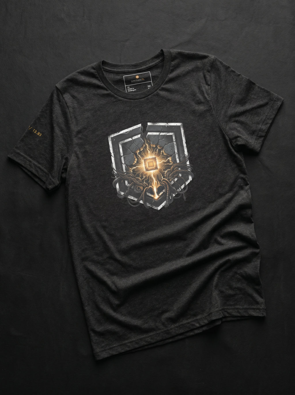 An isolated product flat-lay mockup of the premium dark gray heather cotton t-shirt, laid flat against a clean background. The layout showcases the high-contrast, centered chest graphic of the golden circular micro-chip emblem with sharp technical line accents.